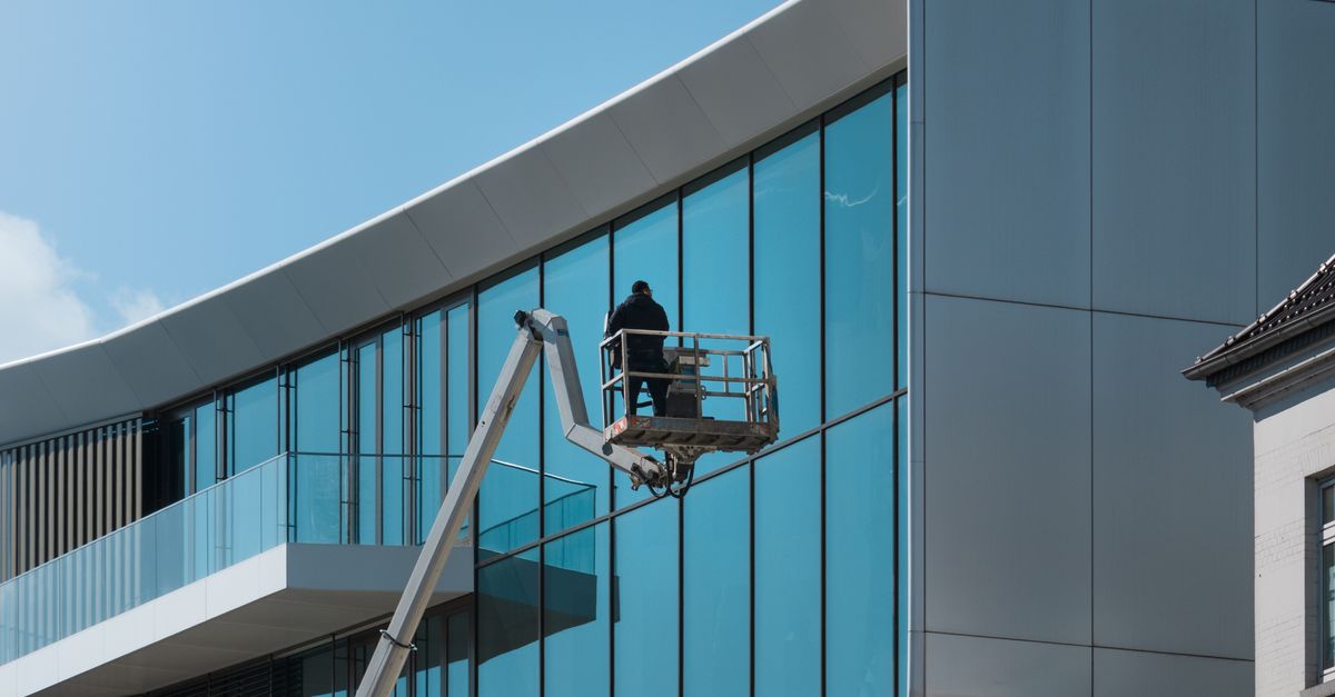 Ladder Clean A man on a ladder cleaning the outside of a building · Free Stock Photo