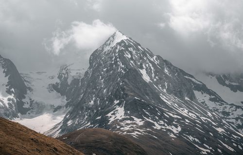 Free A stunning view of snow-capped mountain peaks in Obergurgl, Austria, shrouded by clouds. Stock Photo