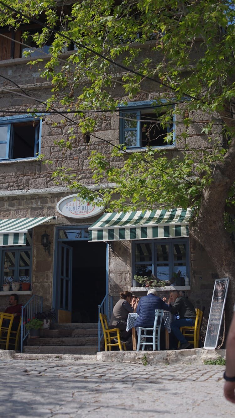 People Sitting In Front Of A Restaurant 