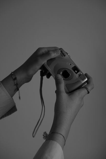 Monochrome image of hands holding an analog camera illustrating classic photography.