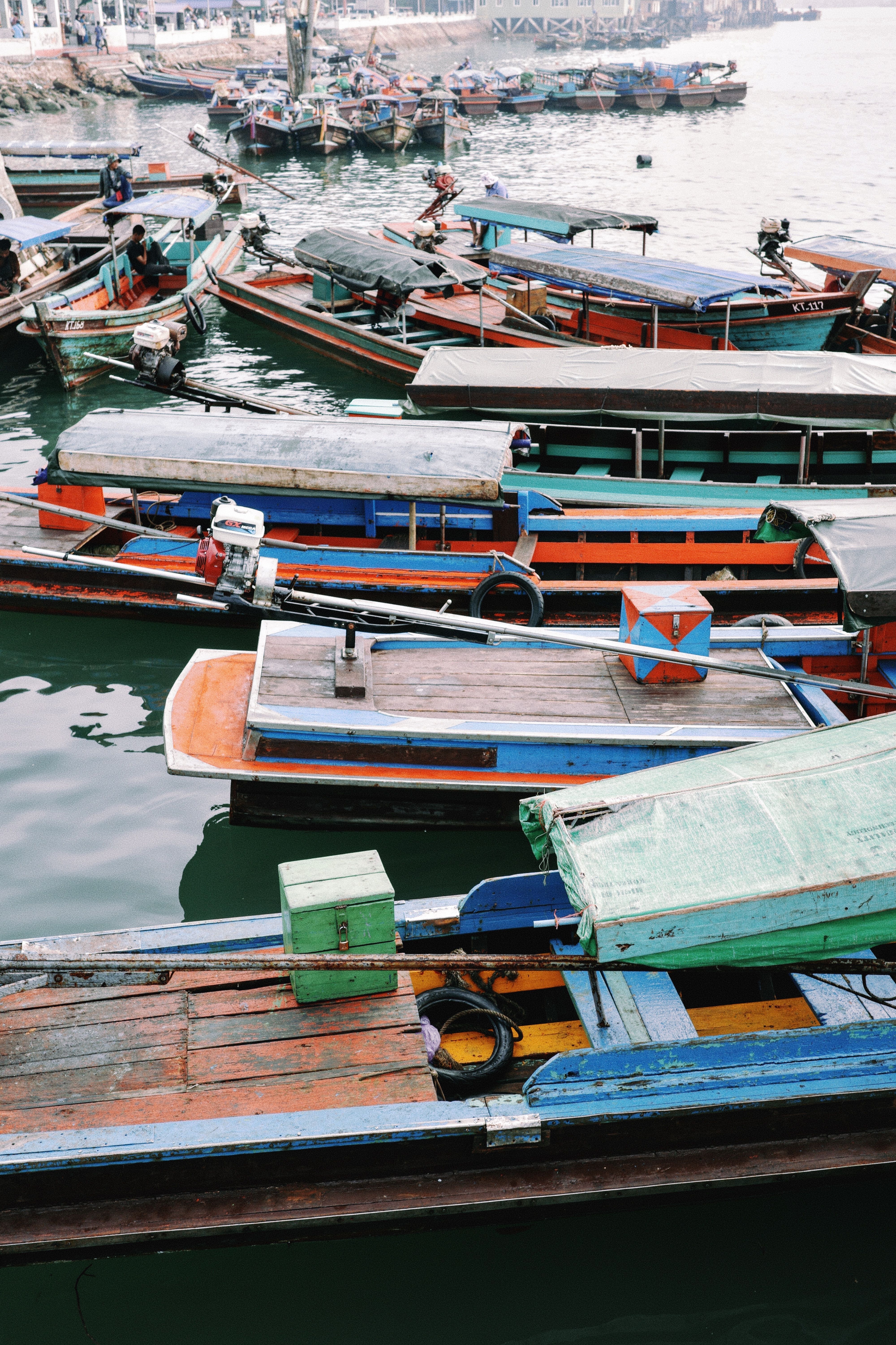 Vibrant longtail boats moored in a bustling harbor showcasing traditional design.