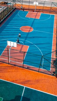 Aerial view of a colorful outdoor basketball court with players in Selçuklu, Konya, Turkey.