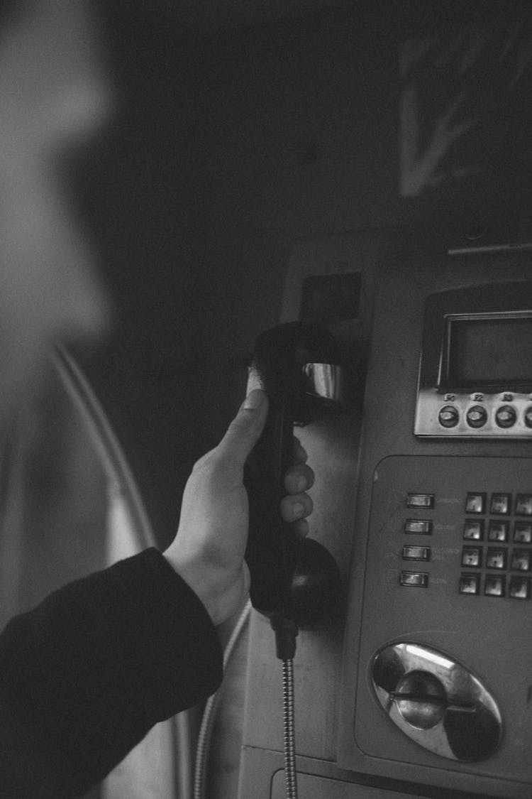 Hand Holding A Public Phone