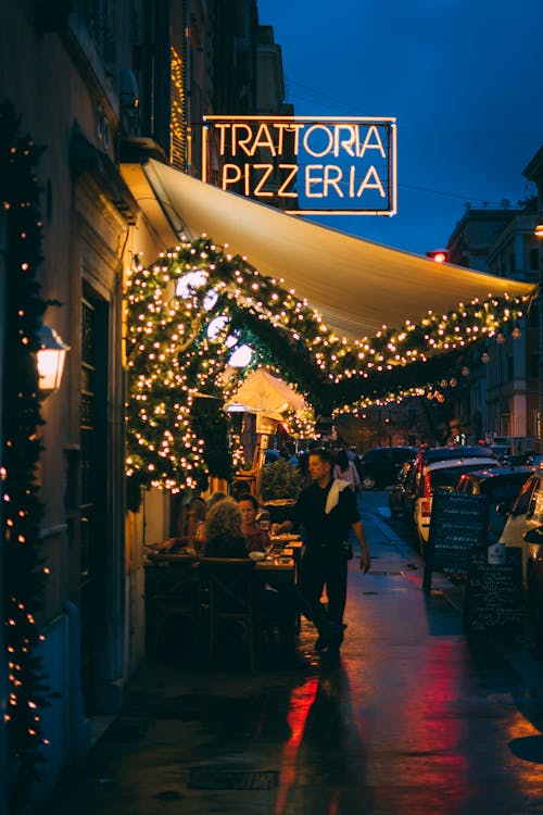 무료 Trattoria Pizzeria 매장 밖에 서있는 남자 스톡 사진