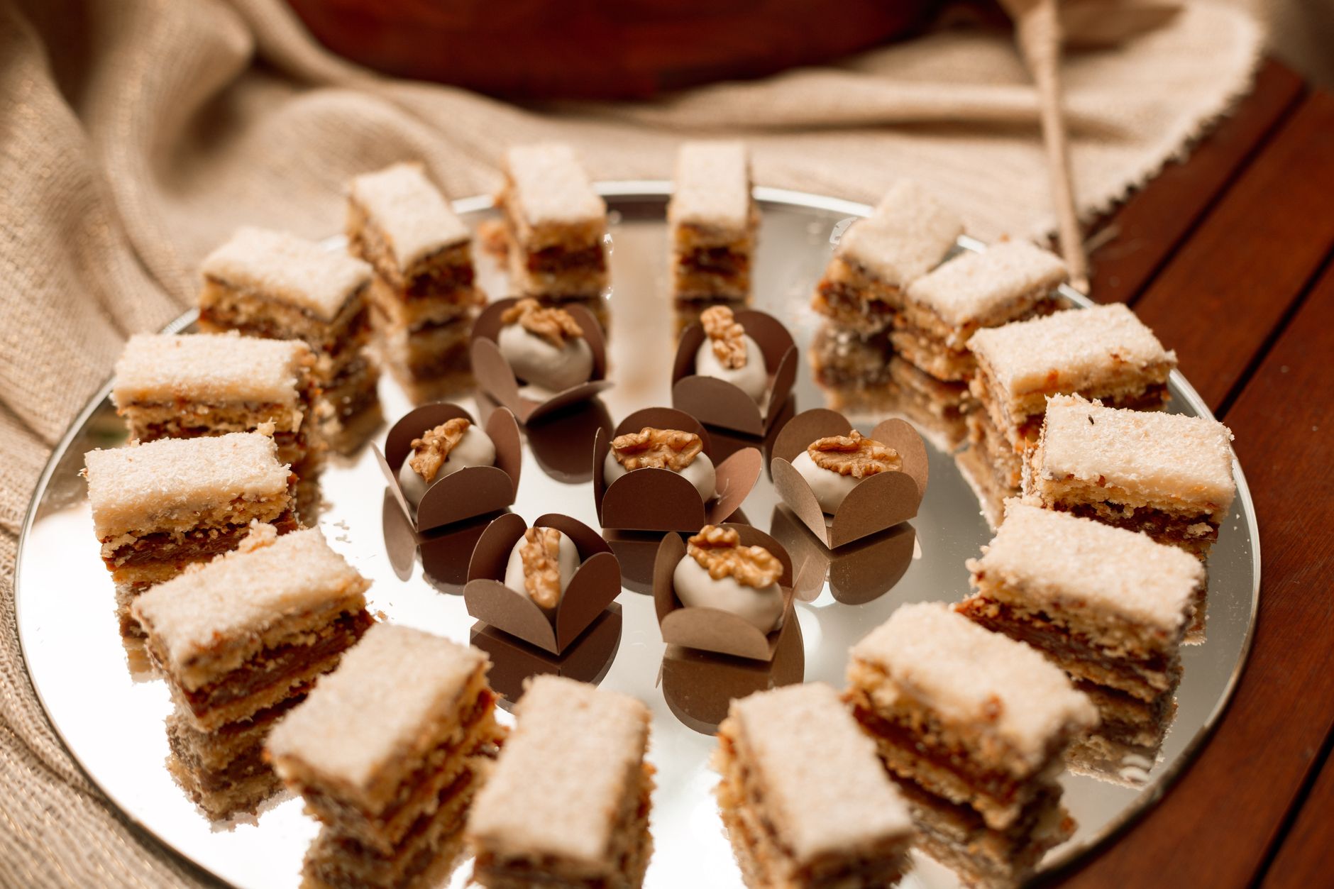 10 Keto Desserts That Will Satisfy Your Sweet Tooth 1 A beautiful display of Brazilian walnut layer cakes and truffles with nuts on a mirrored tray.