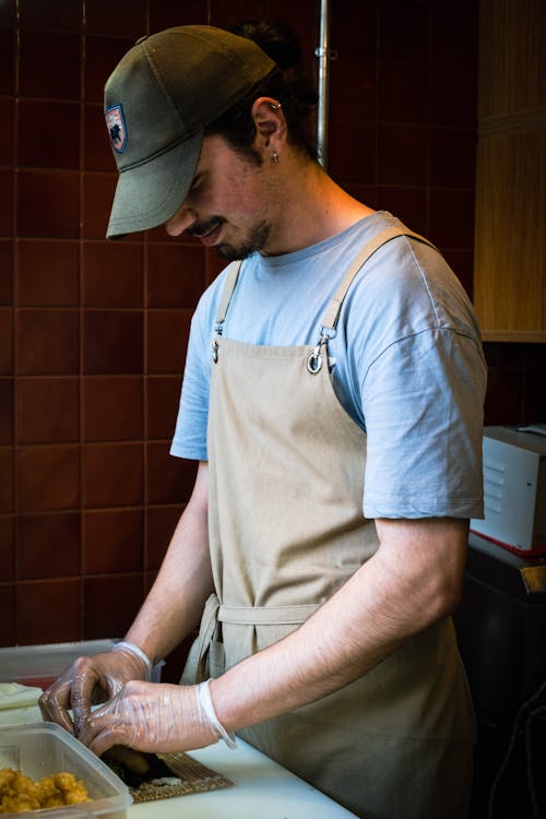 Man in Cap and Apron Working in Kitchen