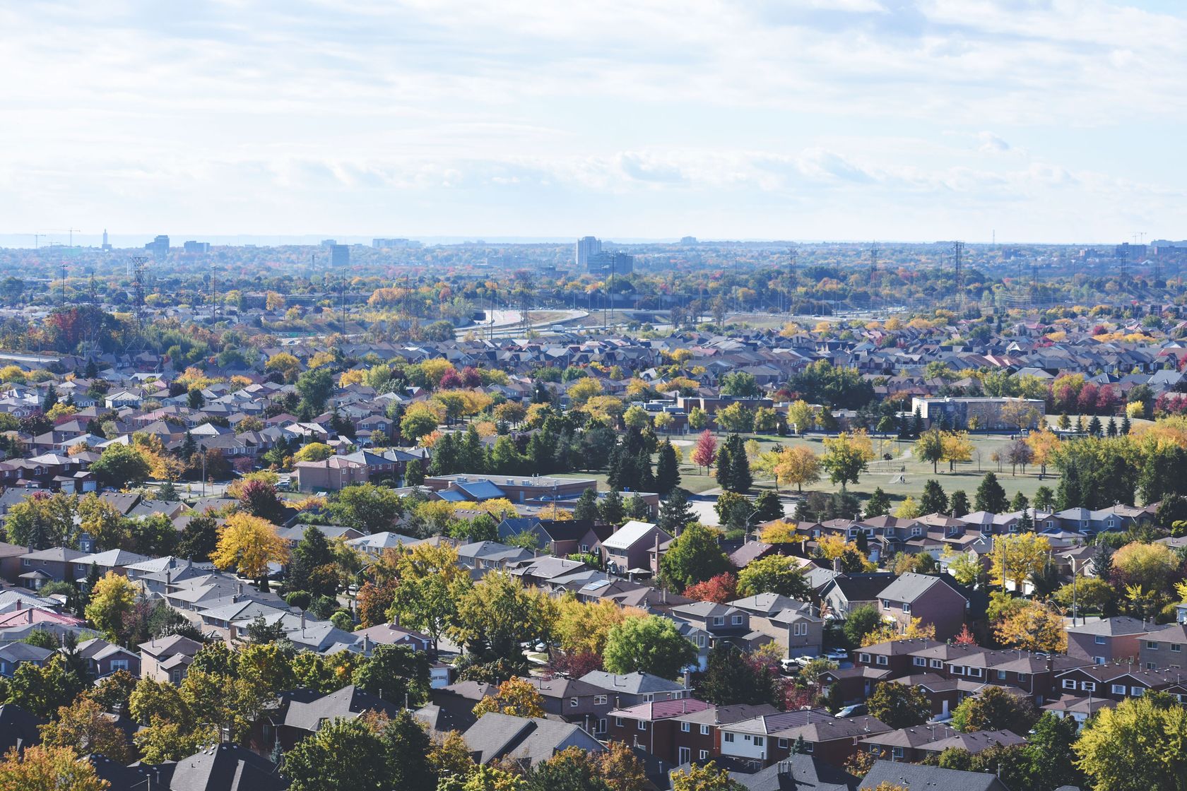 Discover a vibrant aerial view of a suburban neighborhood during autumn, alive with color.
