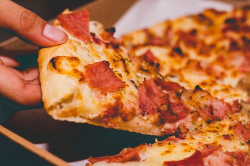 Gratis Foto En Primer Plano De Una Persona Sosteniendo Una Pizza Foto de stock