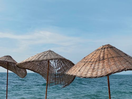 Free Wicker sunshades on a beautiful Turkish beach under clear skies. Stock Photo