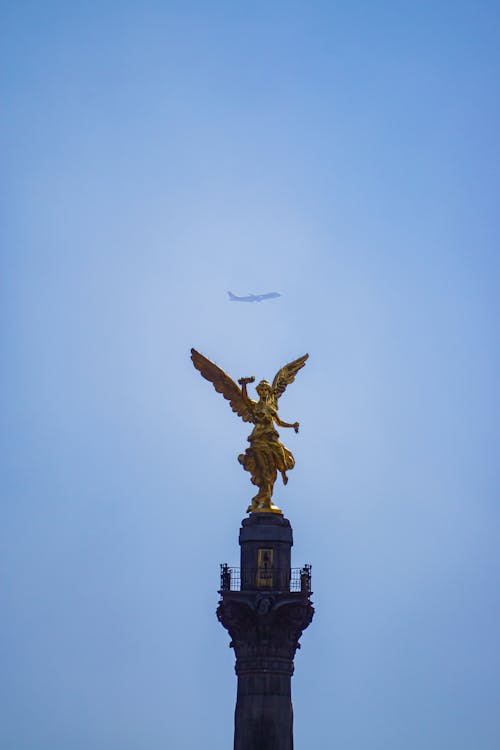 Airplane Flying over the Angel of Independence