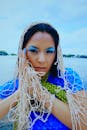 Young Woman in Blue Makeup Wearing a Fishing Net over Her Head