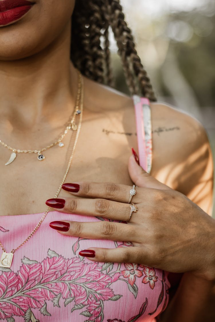 Close-up Of Woman Wearing Jewelry Holding Her Hand On Her Chest 