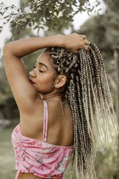 一位扎着辫子、穿着粉色上衣的女士，在户外宁静而时尚地享受活动