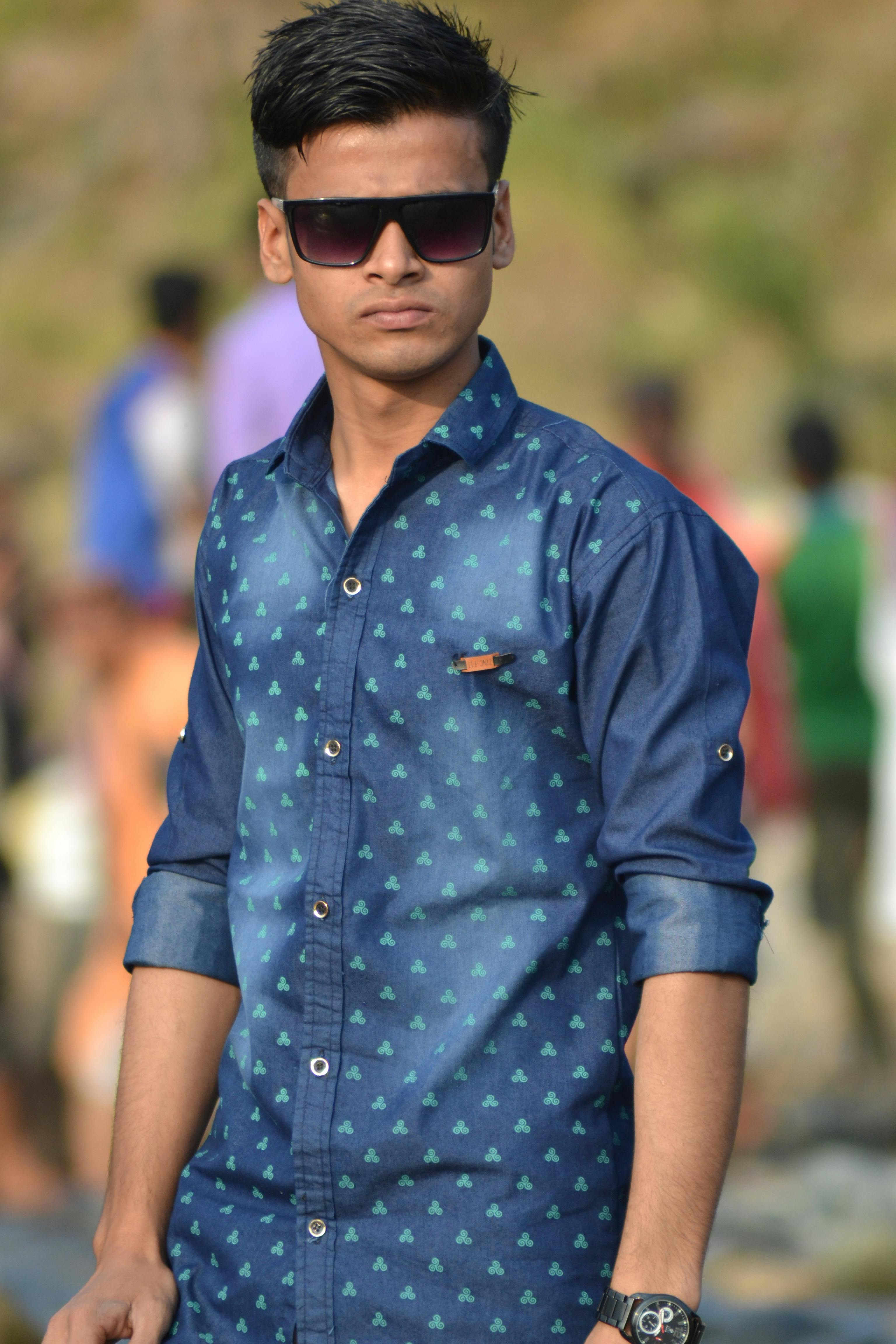 Portrait of a stylish young man in sunglasses, standing outdoors in Bangladesh.