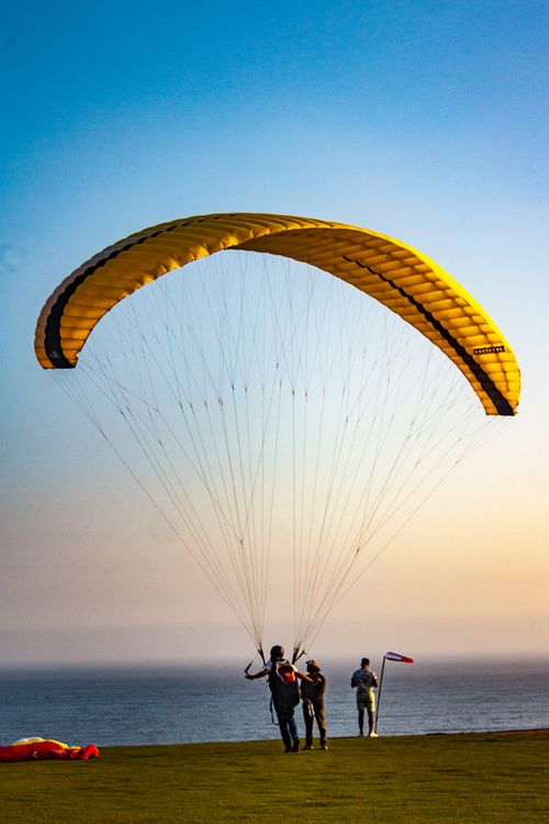 Free Two paragliders prepare to launch over a scenic seaside cliff during a clear day. Stock Photo