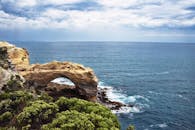 在多云的天空下，海边壮丽的天然岩拱门景色非常适合自然爱好者