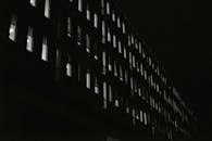 夜晚，一栋引人注目的城市建筑立面，其窗户被灯光点亮，构成了完美的建筑主题