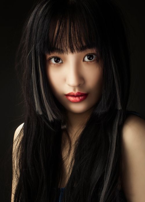 Free A striking portrait of an Asian woman with long black hair and a captivating gaze. Stock Photo