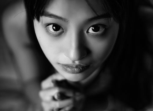 Free Intimate black and white closeup portrait capturing the expressive eyes of a young woman. Stock Photo