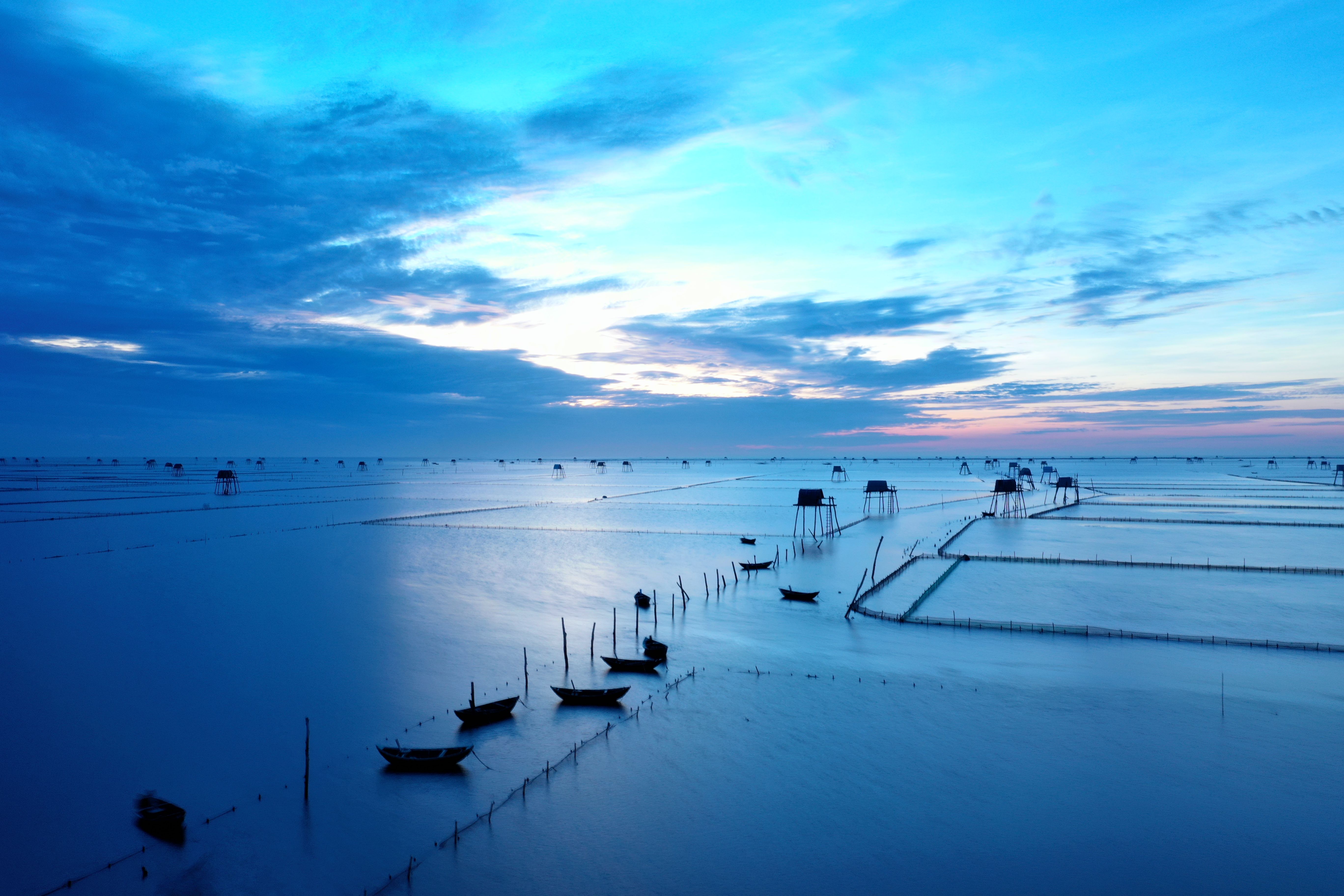 Aerial shot of boats and fishing structures at sunset in Tiền Hải, Vietnam.