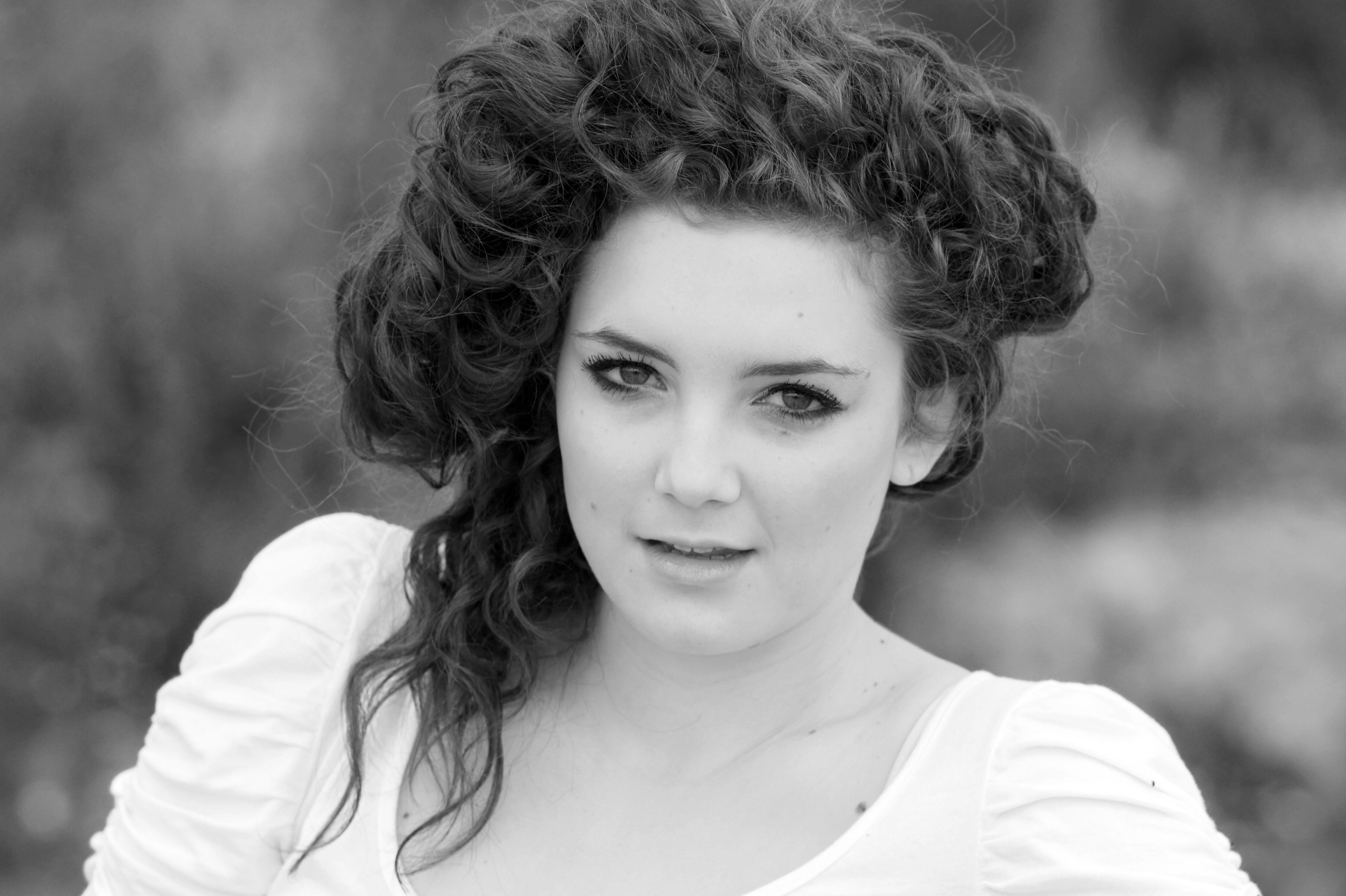 A woman with curly hair posing for a black and white photo · Free Stock ...
