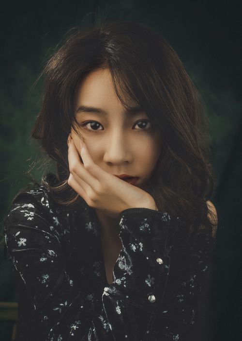 Free Portrait of a thoughtful woman with long hair and black embroidered shirt. Stock Photo