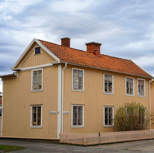 Free Charming wooden house with red roof in a Scandinavian village under an overcast sky. Stock Photo
