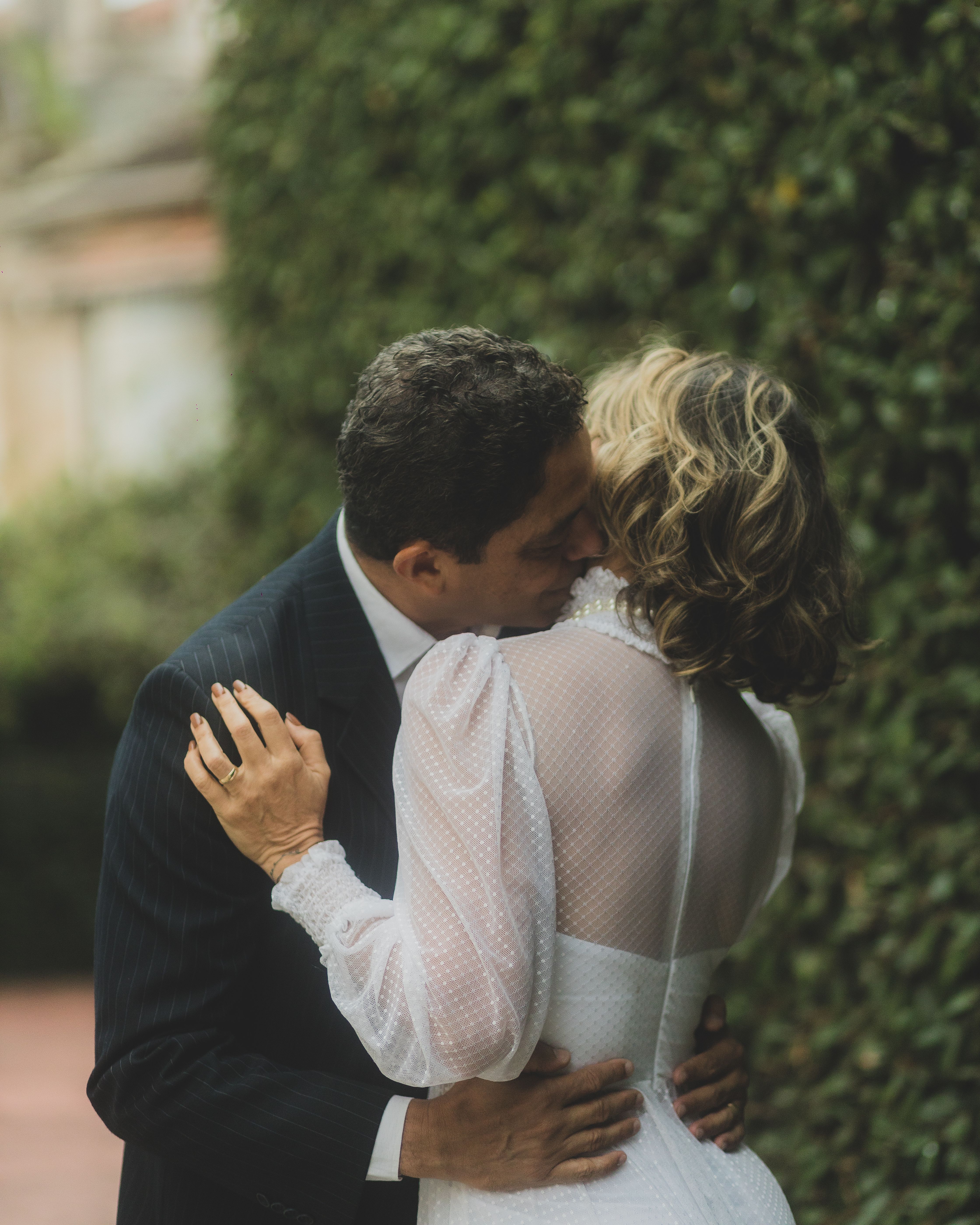 Newlywed couple shares a romantic embrace in an outdoor setting, capturing a special moment.