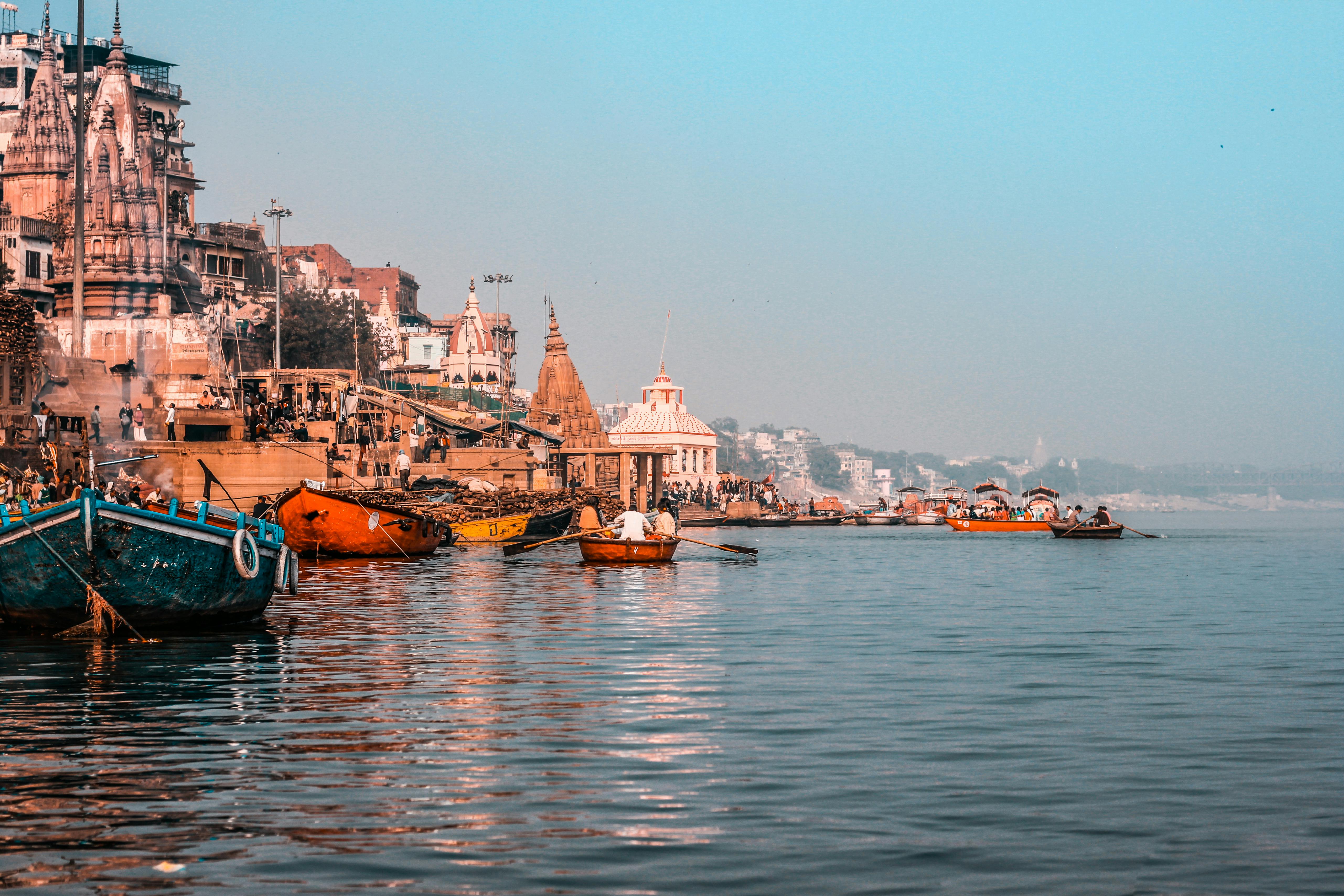 Boats are docked in the water near a city · Free Stock Photo