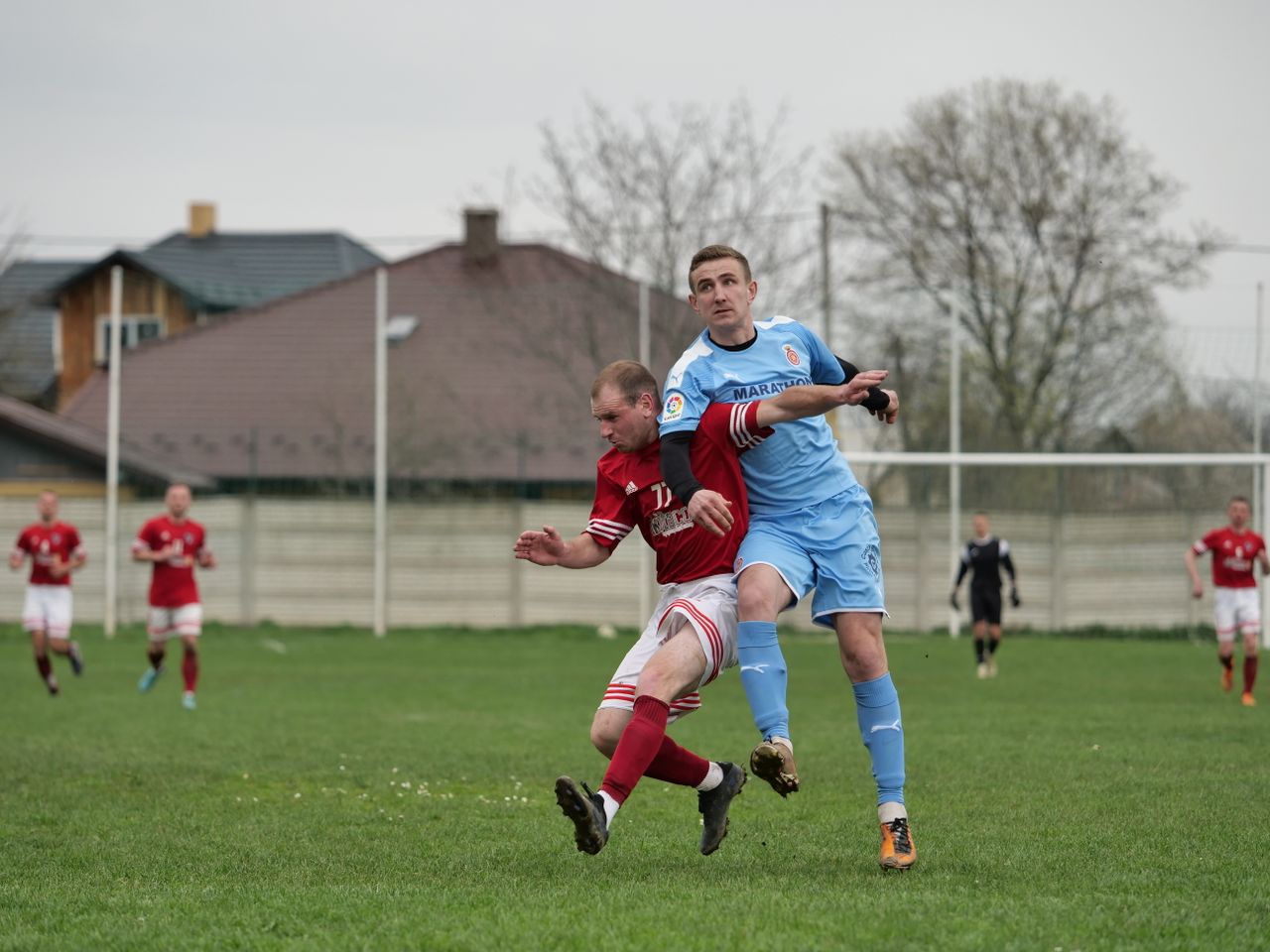 players fiercely competing in a local football match on an outdoor gra