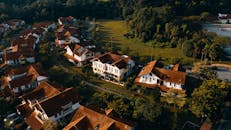 日落时分，从空中俯瞰郊区的房屋，红色屋顶被绿植环绕