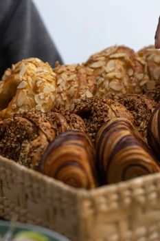 Delicious assortment of pastries in a woven basket, perfect for breakfast.