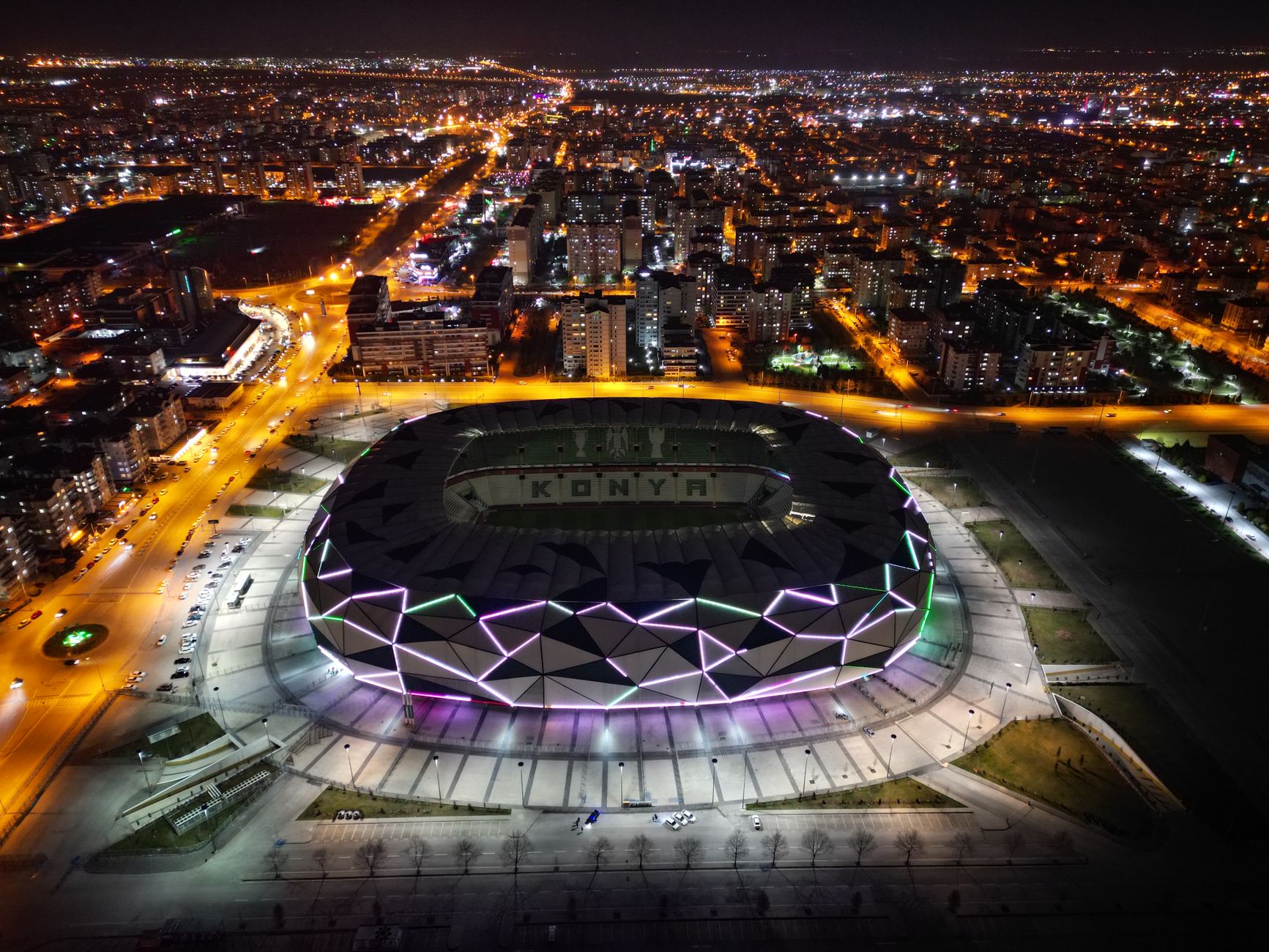 Kansas City stadium glowing under evening lights, football fans gathering outside before a 2026 World Cup match