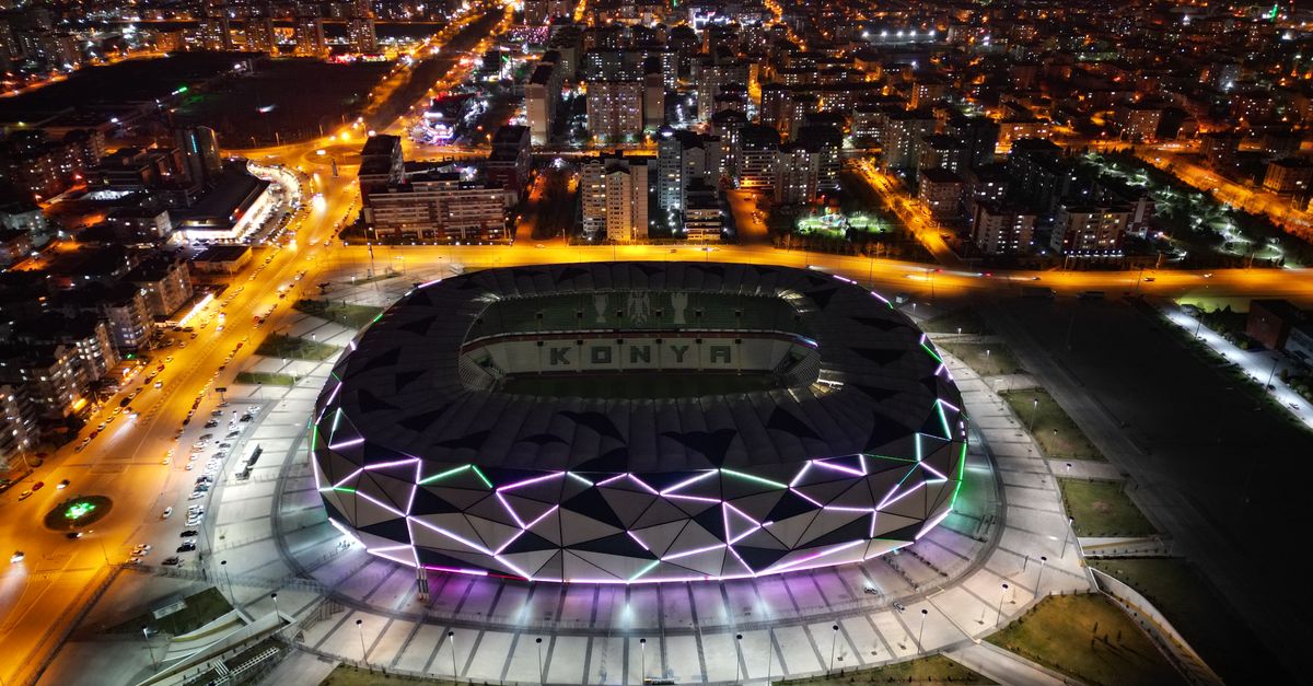 Aerial view of a packed stadium at night during the Eras Tour, glowing with wristband lights