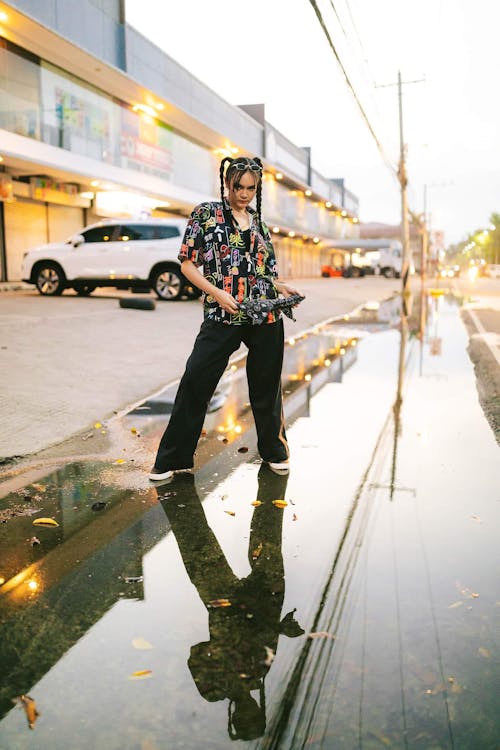 Young Woman with Pigtails Standing in a Puddle on the Street
