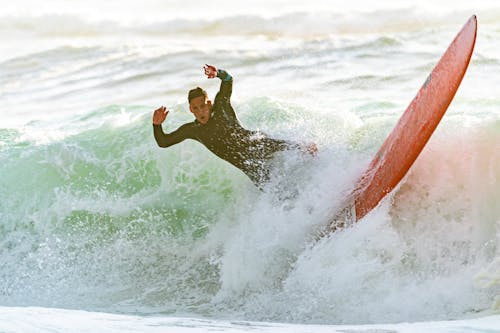 무료 서핑 보드에 파도 타는 남자 스톡 사진