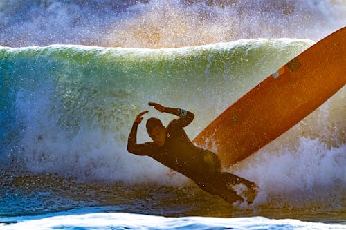 Man Wiping Out of Surfboard