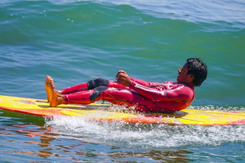Hombre Acostado Sobre Una Tabla De Surf Amarilla