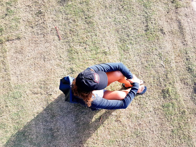 Overhead Photo Of Woman Sitting On Green Grass Field