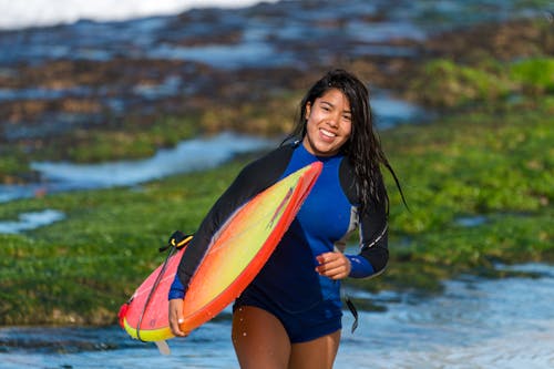 бесплатная Женщина, несущая доску для серфинга Стоковое фото