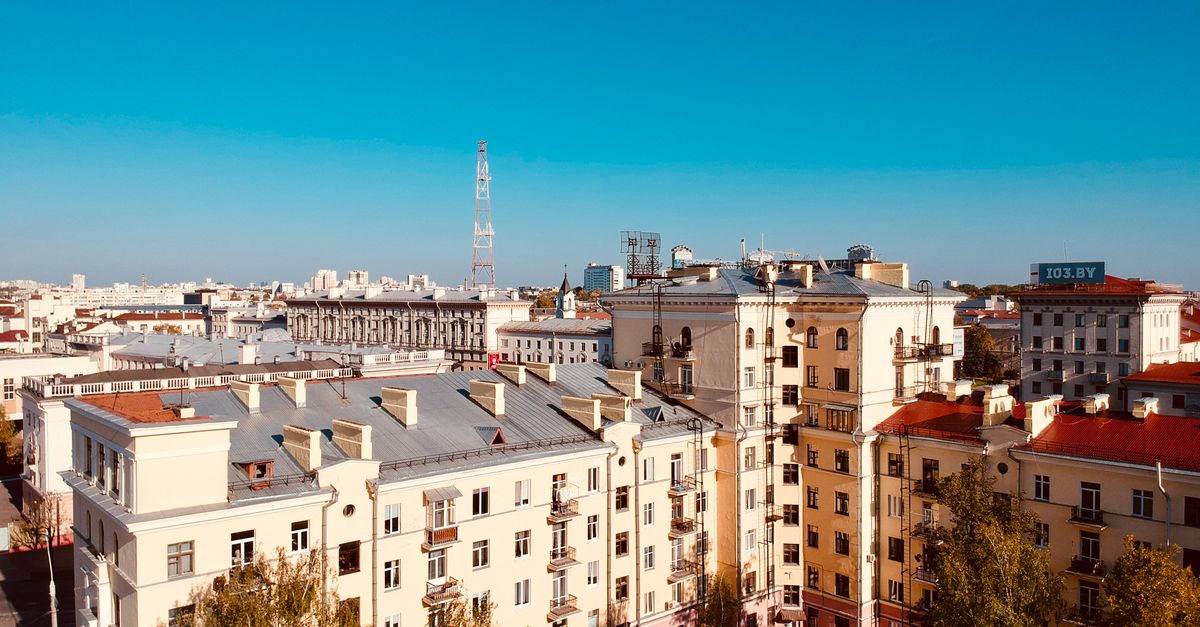 Aerial cityscape of residential buildings in Minsk with a clear blue sky.