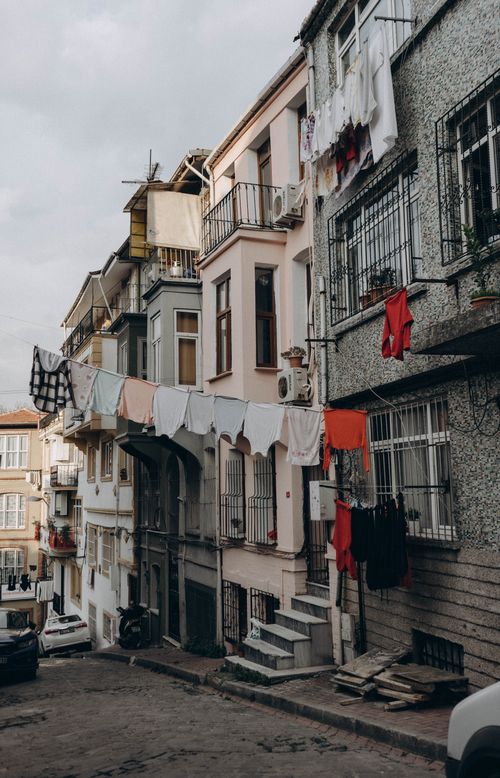 Free Istanbul residential street with colorful laundry hanging between historical buildings creating a vibrant urban scene. Stock Photo