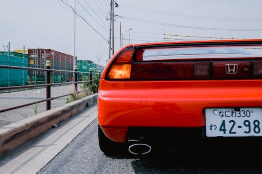 Rear view of a red sports car parked on an empty urban street, showcasing sleek design and vibrancy.