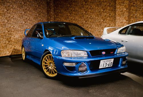 Free Stunning blue Subaru Impreza displayed in a modern, indoor showroom with brick walls. Stock Photo