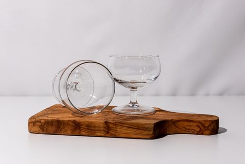 Free Stylish glass goblets on a rustic wooden board showcasing minimalist elegance. Stock Photo