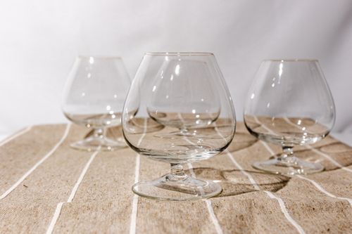 Free Close-up of clean, empty brandy snifters on a rustic fabric table, perfect for bar or dining settings. Stock Photo