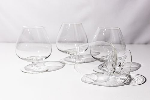 Free Stylish arrangement of transparent brandy snifters casting shadows on a white background. Stock Photo