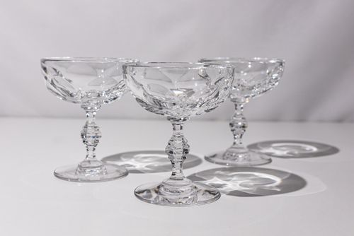 Free Three elegant crystal glasses casting intricate reflections on a smooth surface. Stock Photo