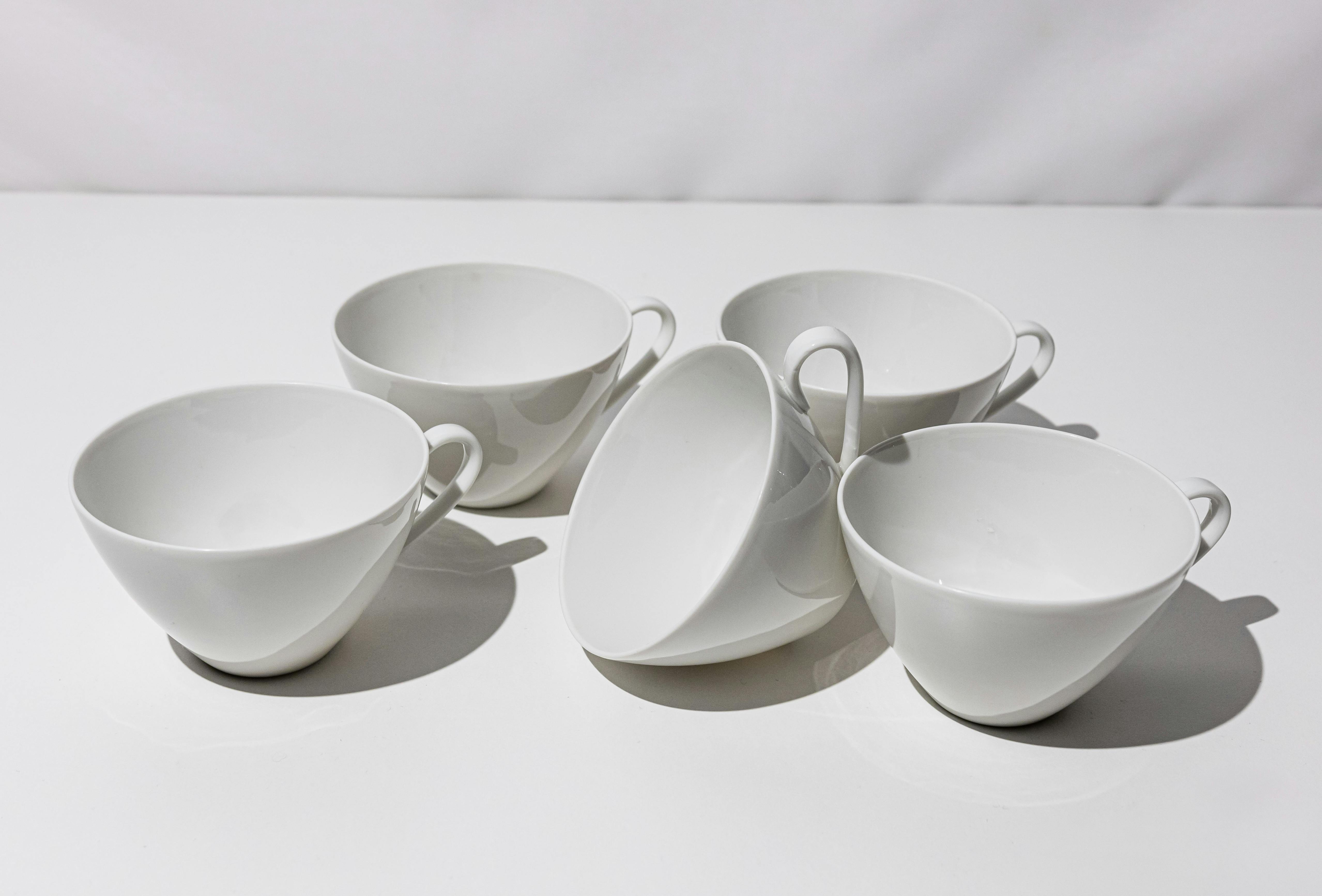 a set of six white cups with handles