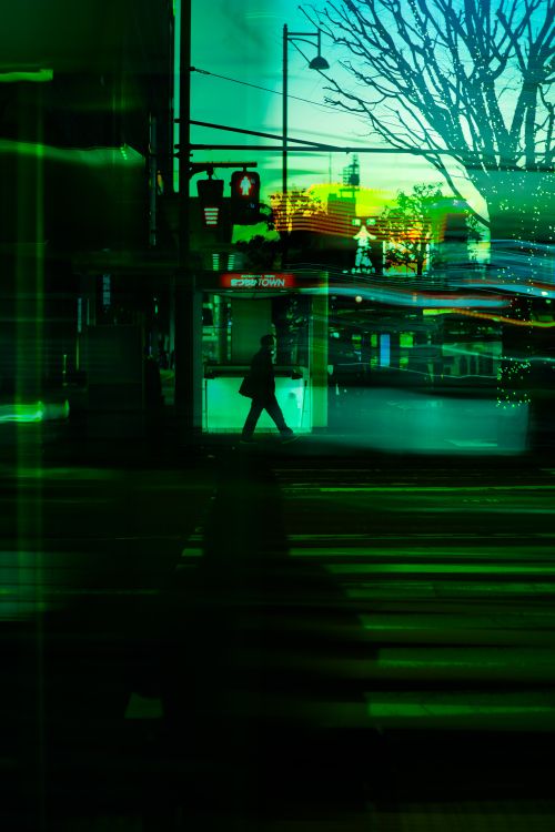 Free A dynamic urban night scene featuring vibrant neon lights, reflections, and a silhouette of a person crossing the street. Stock Photo